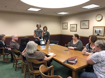 USCL staff sitting at a table being trained to use their new AED device.