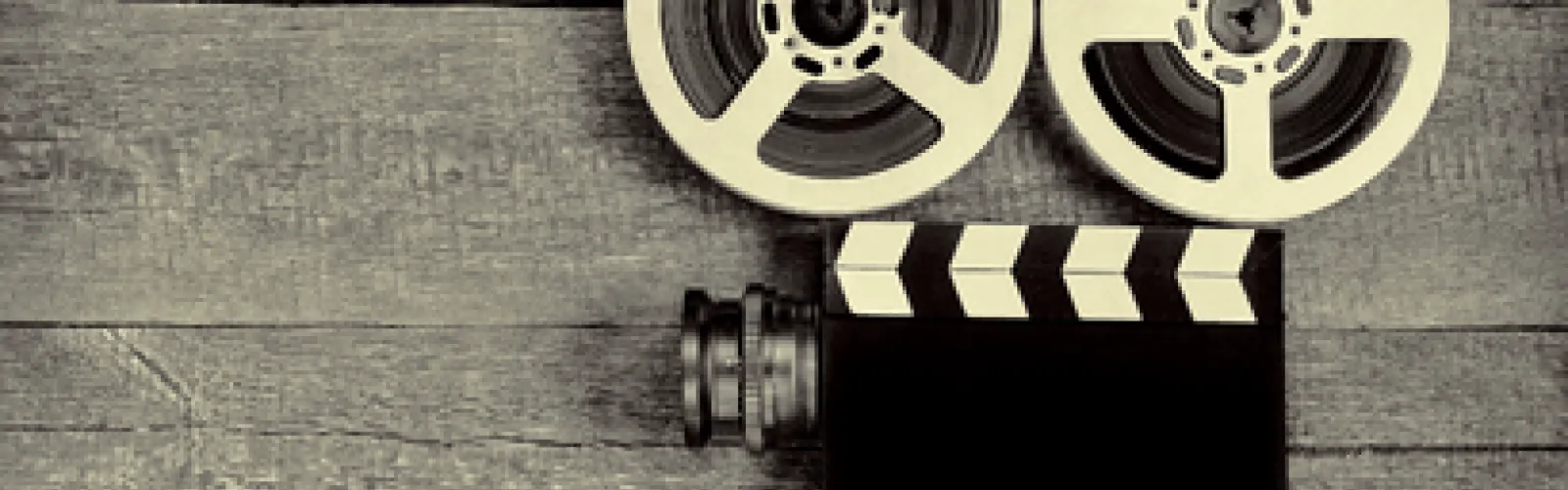 A film camera with reels laying on a table. 