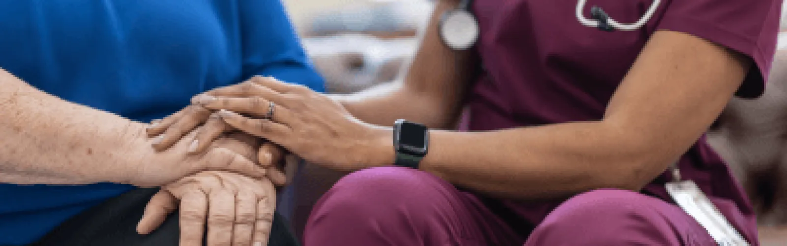 Two people sitting together and holding hands. 