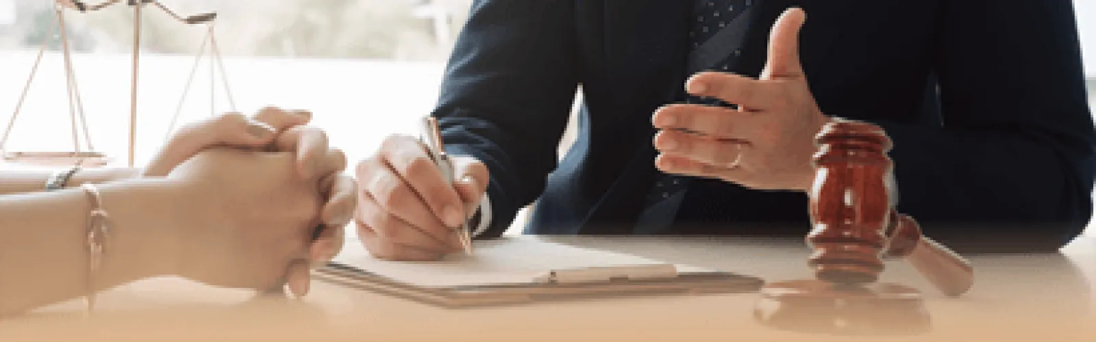 Close-up of two people talking at a table with a focus on their hands. 