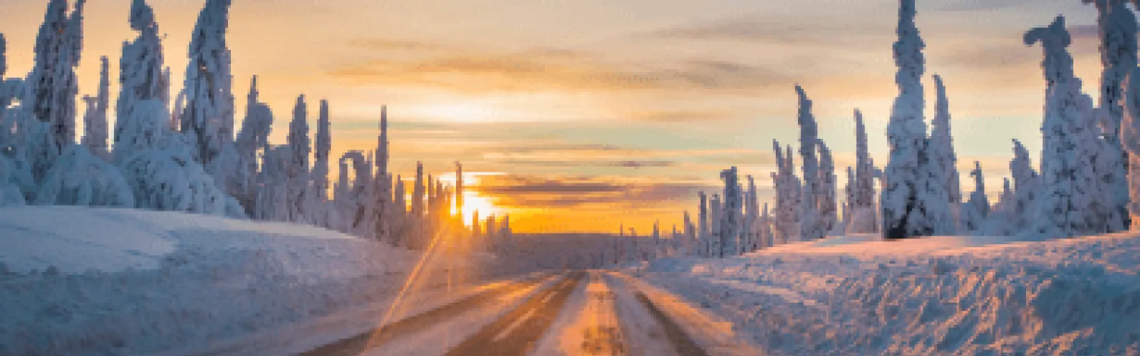 A snow-covered road at sunset. 
